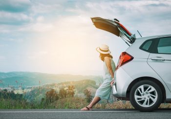 woman sitting on hatchback of rental car in Costa Rica